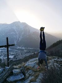 Rear view of man on mountain against sky