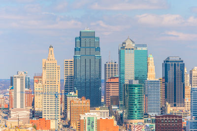 Buildings in city against cloudy sky