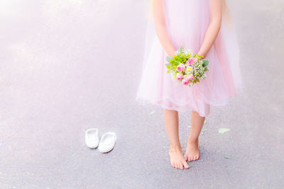 Low section of woman standing on pink flower