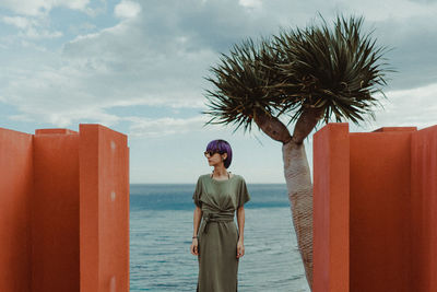 Full length of woman standing at resort against sea