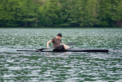 Man in boat on lake against trees