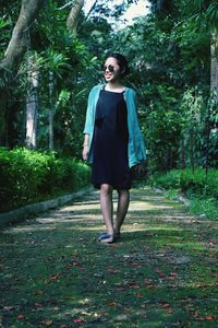 Full length of smiling young woman walking on footpath