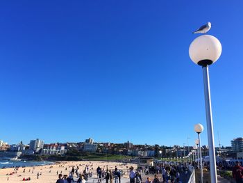 People in city against clear blue sky