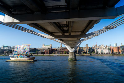 Bridge over river thames against buildings and barges in london city