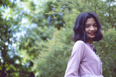 Portraits smiling asian young girl with pine tree in vintage color.