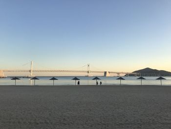 View of suspension bridge over sea against clear sky