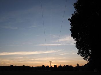 Electricity pylon on landscape against blue sky