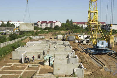 People working at construction site against sky