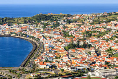 High angle view of townscape by sea against sky