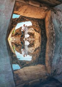 Digital composite image of woman standing on rock