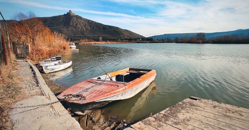 Boats moored in lake against sky