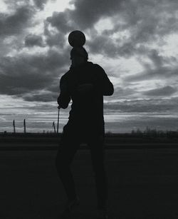 Silhouette of people against cloudy sky