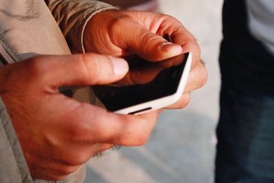 Midsection of man using mobile phone
