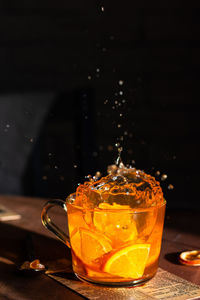 Splash of orange tea in a glass