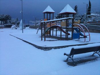 View of snow covered bench on field