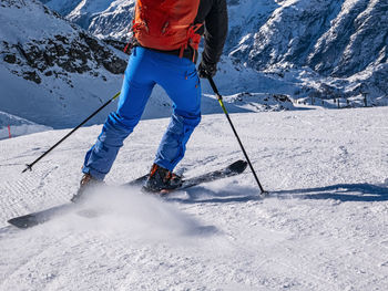 Low section of man skiing on snowcapped mountain