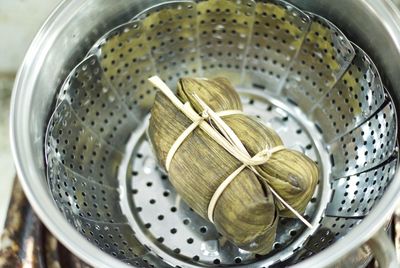 High angle view of tied leaves in colander