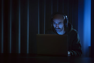 Man working on laptop in dark office