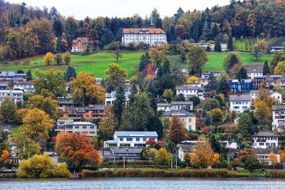 Houses by river in city against sky