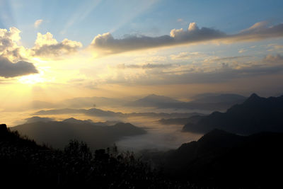 Scenic view of silhouette mountains against sky at sunset