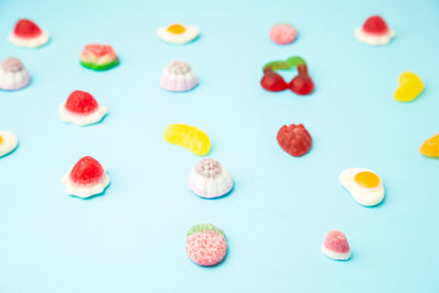 High angle view of multi colored candies against white background