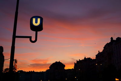 Low angle view of road sign against sky during sunset