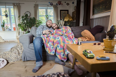 People relaxing on sofa at home