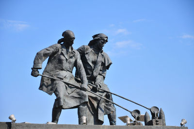 Low angle view of statue against blue sky