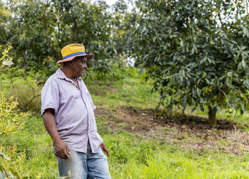 Man wearing hat standing by tree