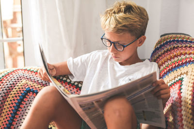 Boy reading newspaper at home