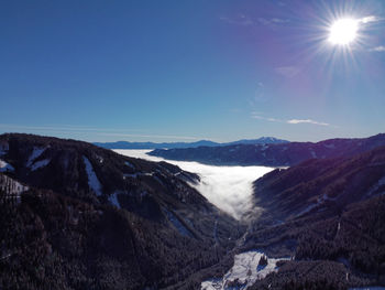 Scenic view of snowcapped mountains against blue sky