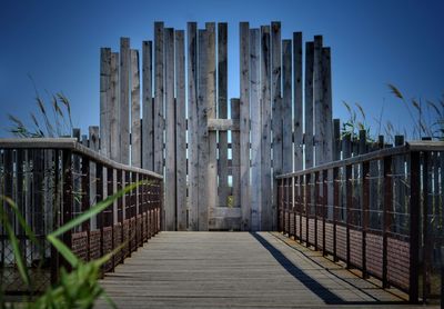 Wooden footbridge against clear sky