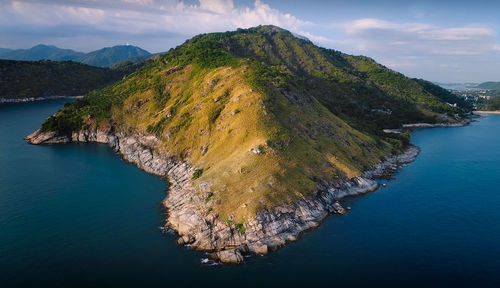 High angle view of sea by mountains against sky