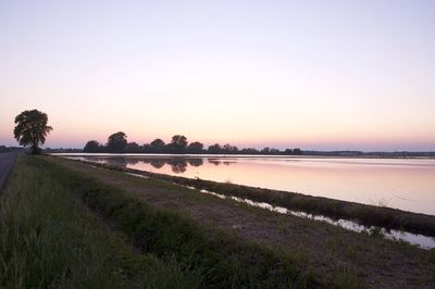 Scenic view of field against clear sky during sunset