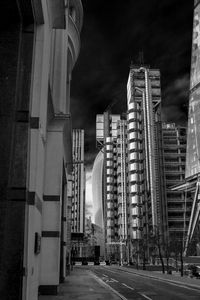 Street amidst buildings against sky at night