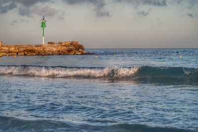 Lighthouse by sea against sky