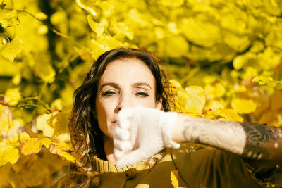 Woman covering her mouth with her tattooed forearm ii