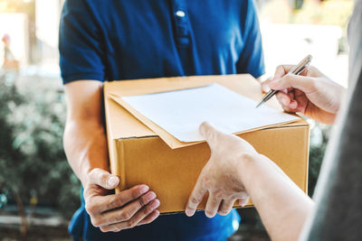 Midsection of couple holding book