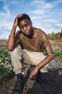 Portrait of young man sitting on land