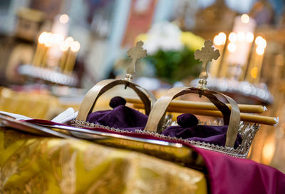 Close-up of crowns on table at orthodox wedding