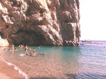 People on rocks by sea