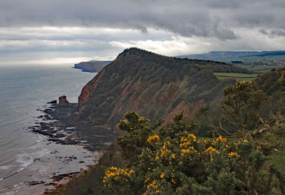 Scenic view of sea and mountains against sky