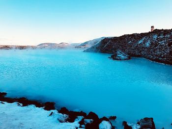 Scenic view of lake against clear blue sky