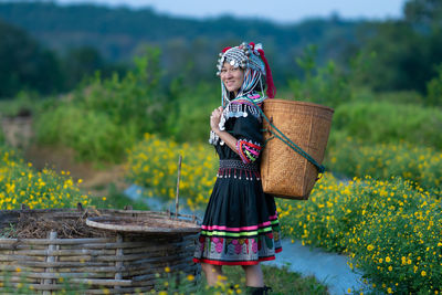 Woman holding umbrella standing against plants