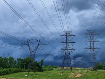 Electricity pylon on field against sky