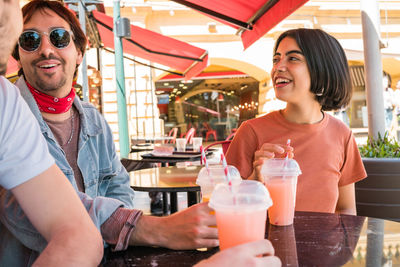 Portrait of a smiling young woman with drink at restaurant