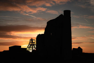 Low angle view of silhouette tower against sky during sunset