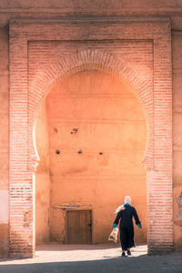 Rear view of woman standing in tunnel