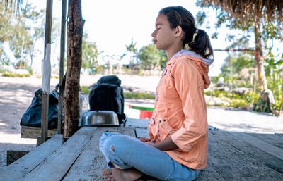 Girl meditating with eyes closed mind training in a quiet old wooden house