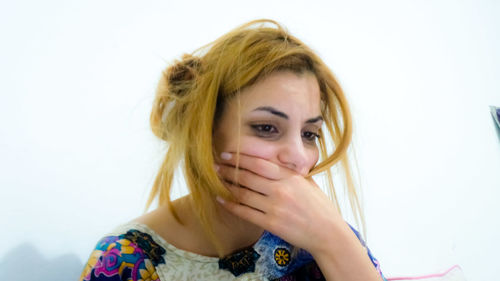Close-up young woman covering mouth